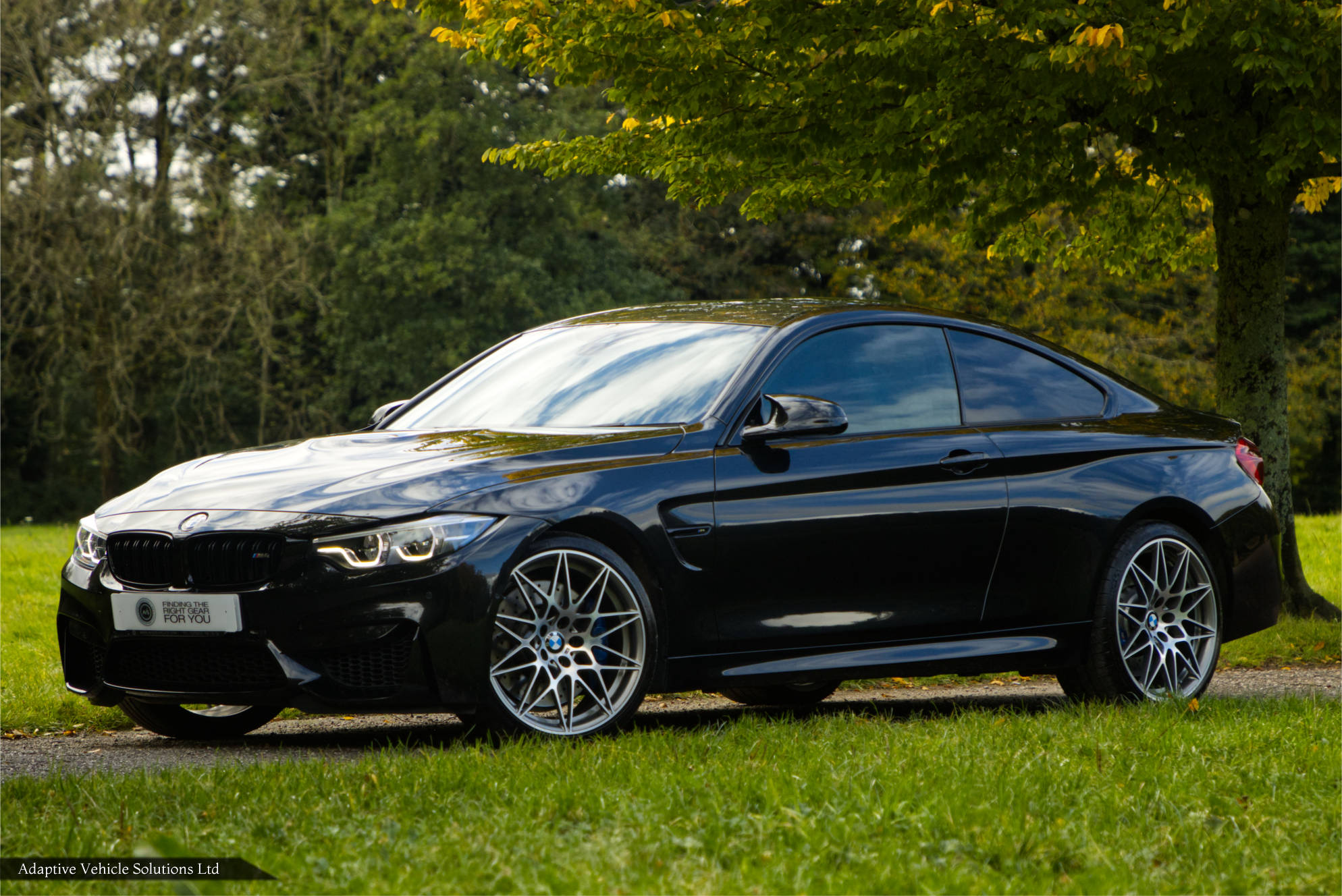BMW M4 Competition black coupe near side front view